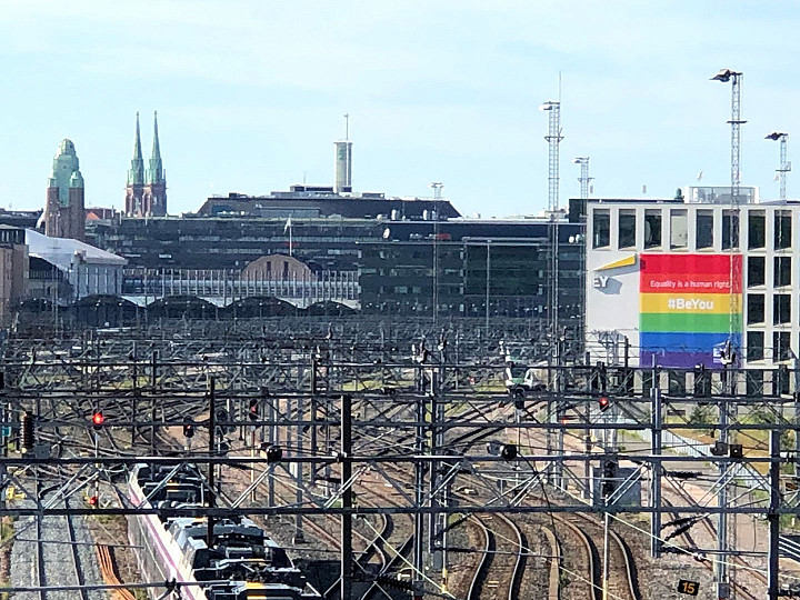 Junalla tulijoita tervehtii sateenkaarilippu.